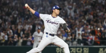 Baseball pitcher on mound, mid-delivery, focused on the catcher