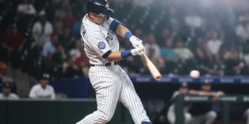 Baseball player making a powerful swing to improve on-base percentage
