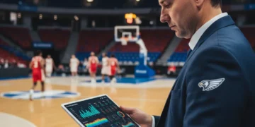 Basketball coach analyzing data on a tablet, revolutionizing coaching strategies.
